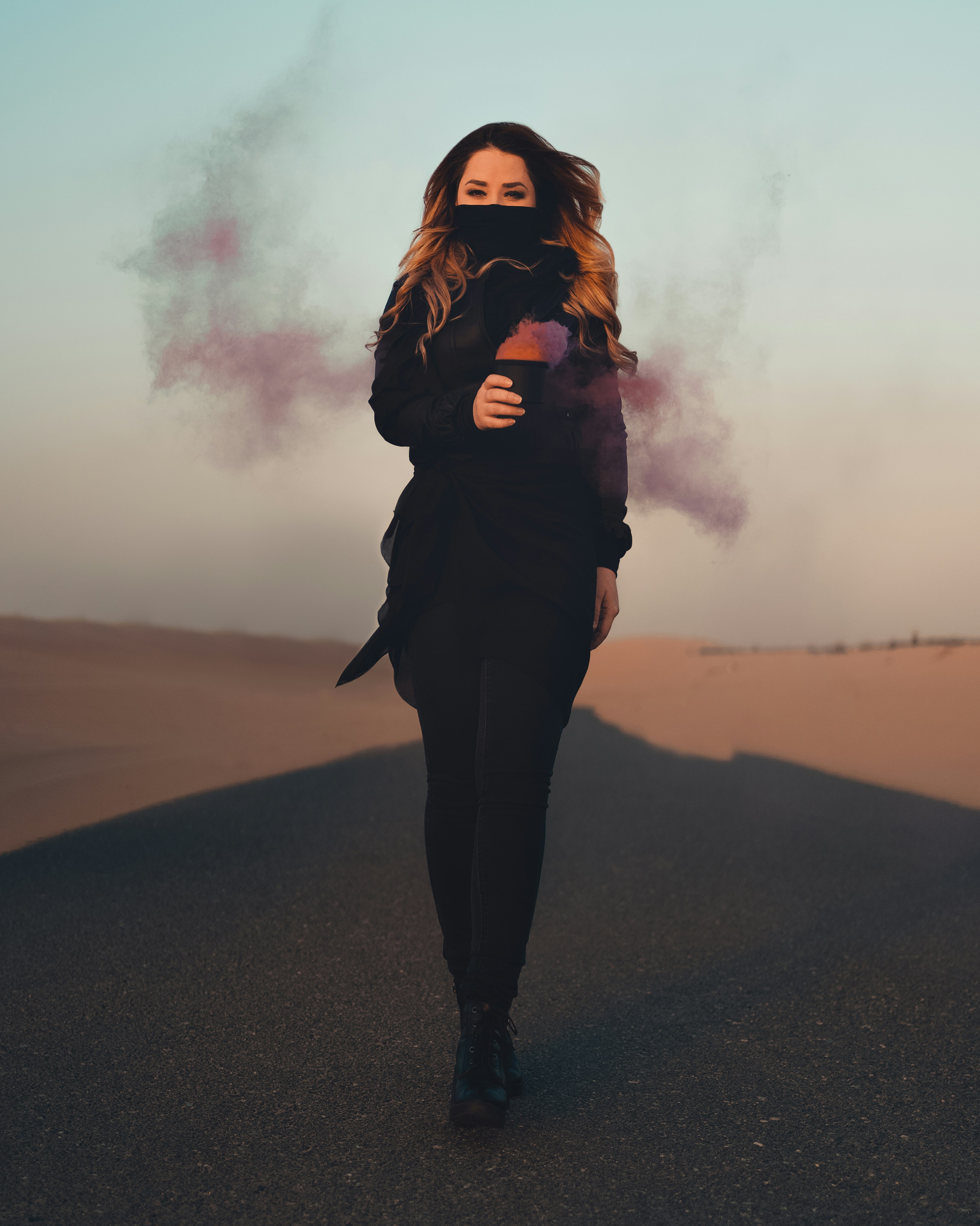 woman in black jacket standing on black asphalt road